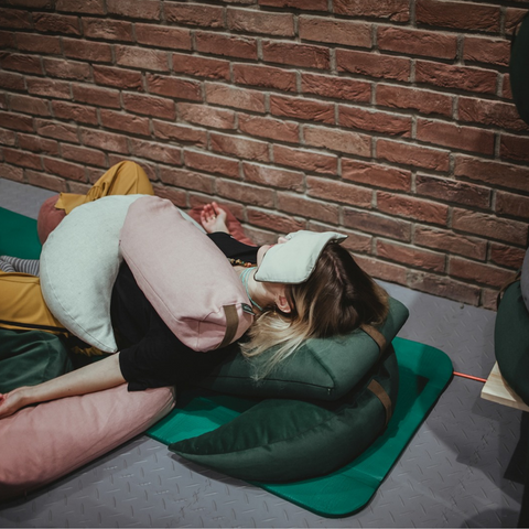 woman relaxing on the mat thanks to buckwheat, polyurethane foam and eye pillows