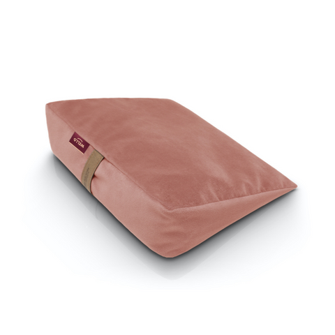 Wedge pillow for sitting in a dark pink velour cover