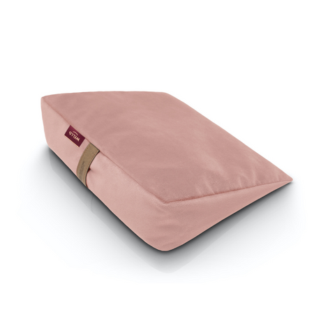 Wedge pillow for sitting in a light pink velour cover