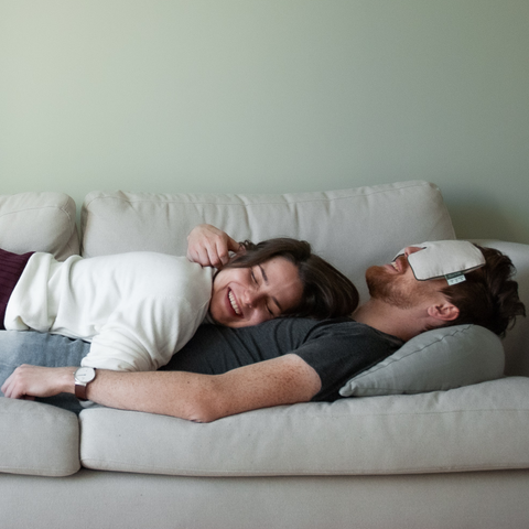 Couple lying on sofa relaxing thanks to buckwheat pillow and lavender eye pillow